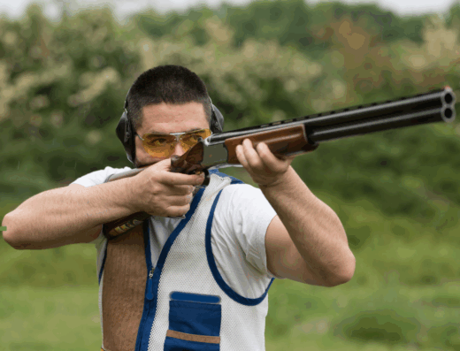 Shotgun shooter focusing on a crossing target in a competitive 5-stand event.